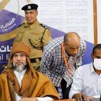 סייף אל-אסלאם קדאפי, משמאל, בנו ויורשו לשעבר של הדיקטטור הלובי המנוח מועמר קדאפי, רושם את מועמדותו לבחירות לנשיאות המדינה בחודש הבא בסבהא, לוב, 14 בנובמבר 2021 | Libyan High National Elections Commission via AP