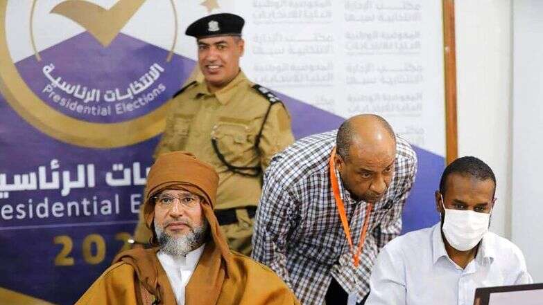 סייף אל-אסלאם קדאפי, משמאל, בנו ויורשו לשעבר של הדיקטטור הלובי המנוח מועמר קדאפי, רושם את מועמדותו לבחירות לנשיאות המדינה בחודש הבא בסבהא, לוב, 14 בנובמבר 2021 | Libyan High National Elections Commission via AP