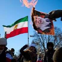 מפגינים שורפים תמונות של המנהיג העליון של איראן, האייתוללה עלי חמינאי | AP