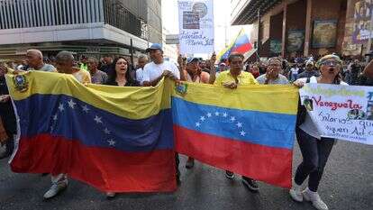 אזרחי ונצואלה עם דגל מדינתם | AFP