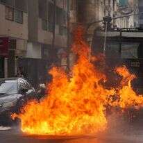 תותח מים של המשטרה מרסס אש שהוצתה על ידי בקבוק תבערה במהלך עימותים בצעדה של איגודי עובדים וקבוצות אופוזיציה בארגנטינה | AP/גוסטבו גארלו