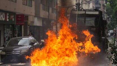 תותח מים של המשטרה מרסס אש שהוצתה על ידי בקבוק תבערה במהלך עימותים בצעדה של איגודי עובדים וקבוצות אופוזיציה נגד הצעת חוק רפורמה בעבודה | AP/גוסטבו גארלו