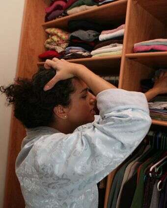 אישה מביטה בארון הבגדים שלה, מנסה להחליט מה ללבוש | יוסי זמיר/Flash90