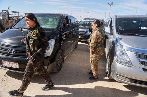 חברות בכוחות הדמוקרטיים הסוריים מאבטחות את האזור כאשר טנדרים הנושאים בני משפחה של חשודים במדינה האסלאמית שהם אזרחים אוסטרלים בדרכם לשדה התעופה בדמשק | P Photo/Baderkhan Ahmad