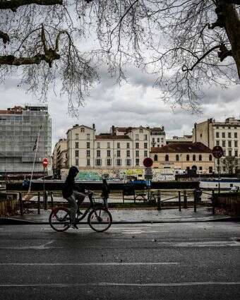 גבר רוכב על אופניים לאורך קיי פולשירון סמוך לזירת הקטטה שגרמה למותו של קוונטין דרנק | OLIVIER CHASSIGNOLE / AFP גבר רוכב על אופניים לאורך קיי פולשירון סמוך לזירת הקטטה שגרמה למותו של קוונטין דרנק | OLIVIER CHASSIGNOLE / AFP