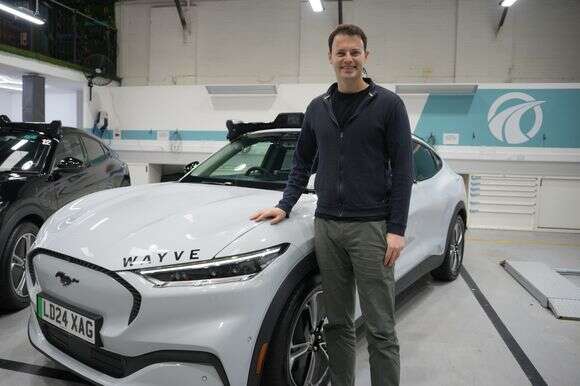 אלכס קנדל, מייסד שותף ומנכ"ל Wayve, מצטלם ליד רכב אוטונומי | AP