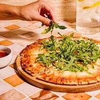 אפילו פיזור של ארוגולה טרייה יכול לשדרג באופן מיידי פיצה קפואה משעממת | לורן בולבין/הוושינגטון פוסט