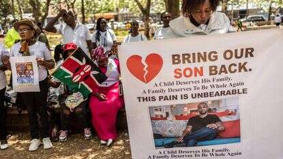 קרובי משפחה של אזרחים קנייתים שגויסו לצבא הרוסי באוקראינה מצטלמים עם תמונות של בני משפחותיהם | AFP