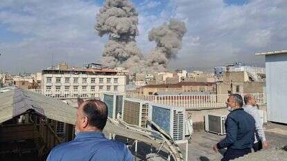 אנשים צופים בעשן עולה מעל קו הרקיע לאחר פיצוץ בטהרן | AP אנשים צופים בעשן עולה מעל קו הרקיע לאחר פיצוץ בטהרן | AP