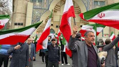 קבוצת גברים מנופפת בדגלי איראן בהפגנה לתמיכה בממשלה ונגד תקיפות אמריקאיות וישראליות בטהרן | AP