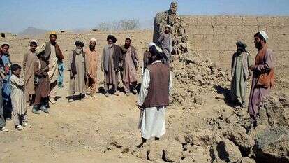 תושבים בוחנים את הנזק שנגרם כתוצאה מתקיפת אוויר אמריקאית בכפר דה סבז, מצפון לבירה האפגנית קאבול ב-10 באוקטובר 2001 | AP/אמיר שאה