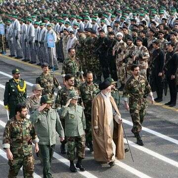 המנהיג העליון של איראן, אייתוללה עלי חמינאי, הולך עם מפקדים איראנים ליד אנשי מיליציית הבסיג' בטהרן | AFP