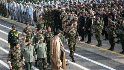 המנהיג העליון של איראן, אייתוללה עלי חמינאי, הולך עם מפקדים איראנים ליד אנשי מיליציית הבסיג' בטהרן | AFP