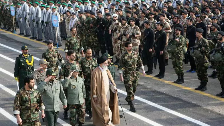 המנהיג העליון של איראן, אייתוללה עלי חמינאי, הולך עם מפקדים איראנים ליד אנשי מיליציית הבסיג' בטהרן | AFP