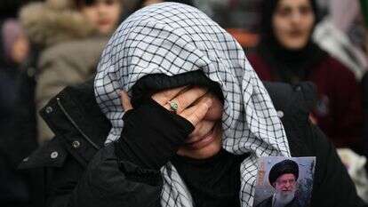 מפגינים אוחזים בתמונה של האייתוללה עלי חמינאי כשהם מתאספים במחאה נגד התקיפה האמריקאית וישראלית על איראן | AFP