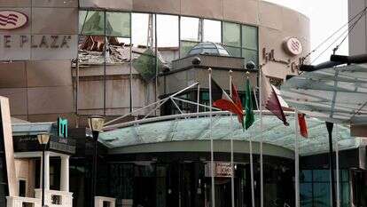 דגלי מדינה בינלאומיים מתנפנפים מחוץ למלון קראון פלאזה שניזוק, לאחר תקיפה צבאית איראנית, בדוחה | : פאדל מאדאן / AFP