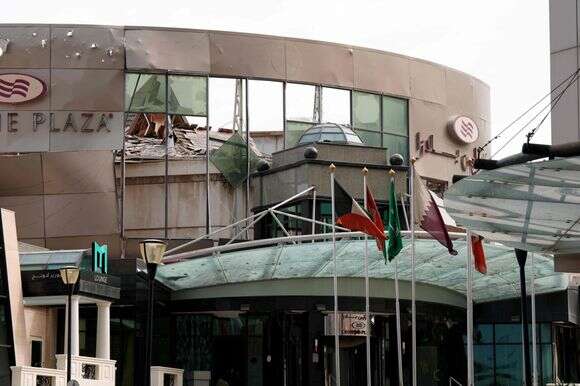 דגלים בינלאומיים מתנפנפים מחוץ למלון קראון פלאזה, שניזוק לאחר תקיפה צבאית איראנית, בדוחה | : פאדל מאדאן / AFP