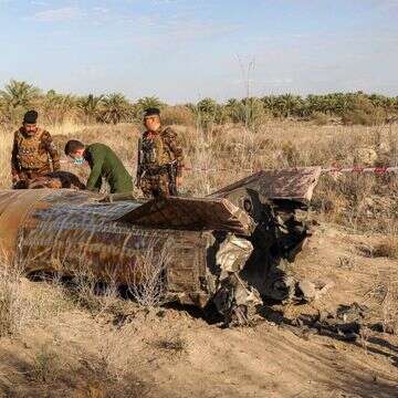 קצינים ממנהלת חומרי הנפץ של משרד הפנים העיראקי בודקים את מיכל הדלק של רקטה שנחתה בכפר כפרי באזור סיחי ליד העיר חילאה במחוז באביל | כראר ג'אבר / AFP