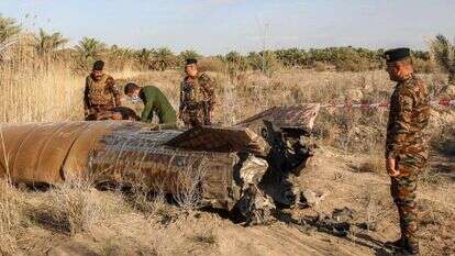 קצינים ממנהלת חומרי הנפץ של משרד הפנים העיראקי בודקים את מיכל הדלק של רקטה שנחתה בכפר כפרי באזור סיחי ליד העיר חילאה במחוז באביל | כראר ג'אבר / AFP