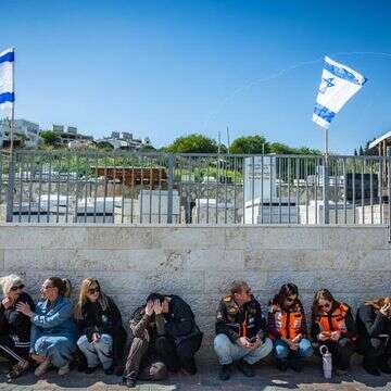 חברים ובני משפחה תופסים מחסה בזמן אזעקות בהלווייתן של רונית אלמליך ואמה שרה אלמליך, שנהרגו בתקיפת טילים בליסטיים איראניים בבית שמש | יונתן זינדל, פלאש 90
