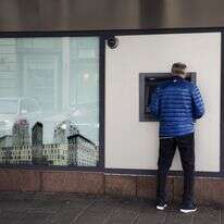 לקוח משתמש במכשיר כספומט מחוץ לסניף בנק | קירה ליין/בלומברג