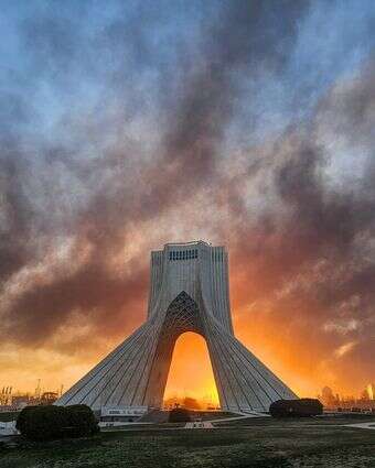 עשן עולה מאחורי אנדרטת אזאדי  בטהרן, איראן, ב-3 במרץ 2026, לאחר המתקפה הצבאית האמריקאית-ישראלית | דאווד ע'הרדר/איסנא דרך AP