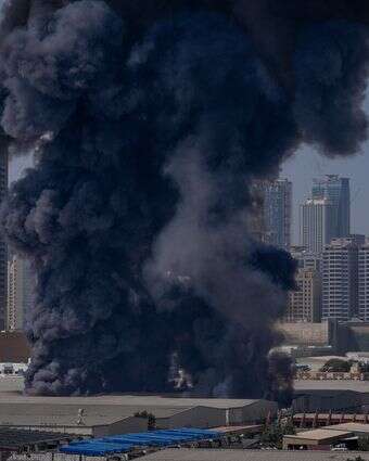 ענן עשן שחור עולה ממחסן באזור התעשייה של העיר שארג'ה בעקבות דיווחים על תקיפות איראניות בדובאי, איחוד האמירויות הערביות | AP/אלטף קאדרי