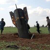 ילדים משחקים סביב טיל שלא התפוצץ שנחת בשדה פתוח בסוריה | דליל סולימאן / AFP