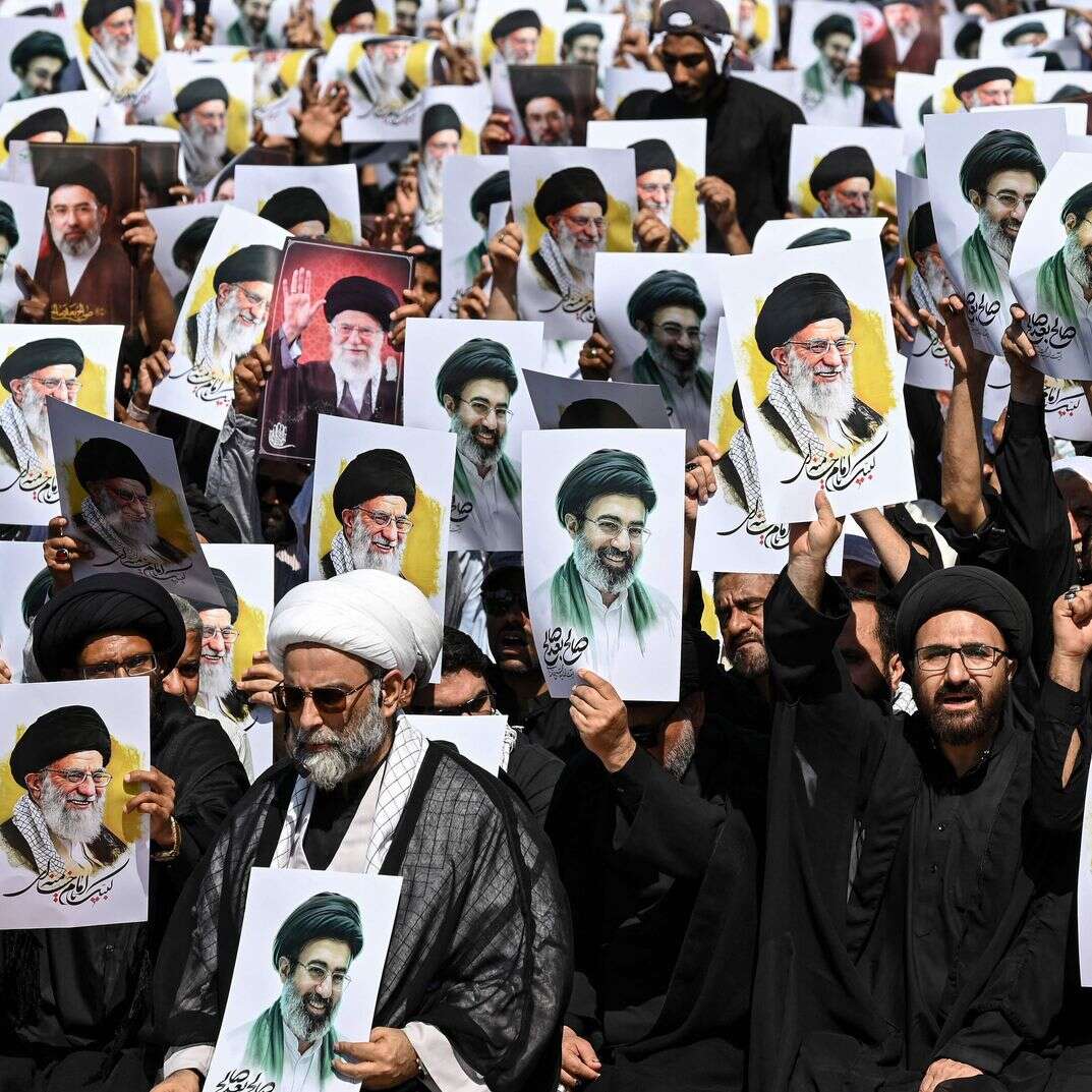 מפגינים בעיר קראצ'י מניפים השבוע את תמונותיהם של עלי ומוג'תבא חמינאי | AFP