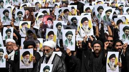 מפגינים בעיר קראצ'י מניפים השבוע את תמונותיהם של עלי ומוג'תבא חמינאי | AFP