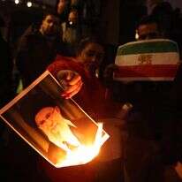 מפגינים הציתו דיוקן של המנהיג העליון של איראן, עלי חמינאי, בעת השתתפותם בעצרת תמיכה בתנועת המחאה הנוכחית באיראן | EPA/NEIL HALL