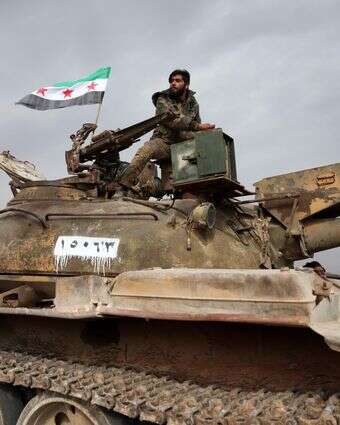 חיילים סורים רוכבים על טנק | עומר חאג' קאדור / AFP