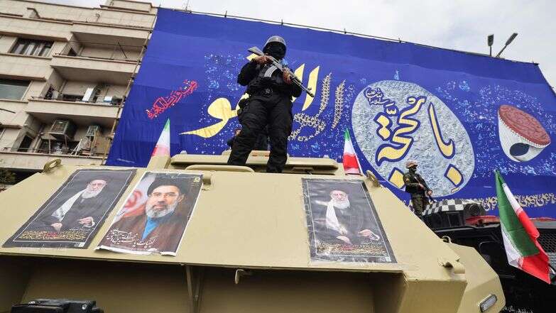 חיילי משמרות המהפכה עומדים על כלי רכב משוריינים עם תמונות המנהיג העליון שחוסל, עלי חמינאי, ובנו, שנבחר למחליפו | AFP