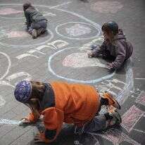 משפחה יהודית דתית נראתה מציירת בגיר על המדרכה את קערת הסדר של פסח במרכז ירושלים | הדס פרוש/Flash90