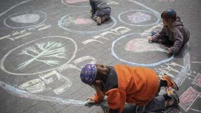 משפחה יהודית דתית נראתה מציירת בגיר על המדרכה את קערת הסדר של פסח במרכז ירושלים | הדס פרוש/Flash90
