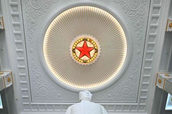 סמל הכוכב האדום נראה מעל פסל של המנהיג הקומוניסטי המנוח מאו דזה-דונג במוזיאון הצבאי | אדק ברי / AFP