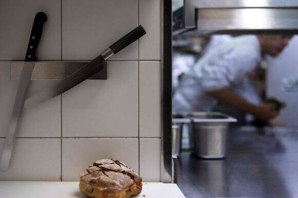 סכינים וכיכר לחם במטבח מסעדת שף | ג'ואל סאגט / AFP