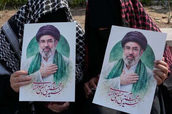 נשים אוחזות בפוסטרים של המנהיג העליון של איראן, האייתוללה מוג'טבה חמינאי, במהלך קמפיין תמיכה בממשלה בכיכר אנקלאב-א-אסלאמי, או המהפכה האסלאמית, במרכז העיר טהרן, איראן | AP/Vahid Salemi