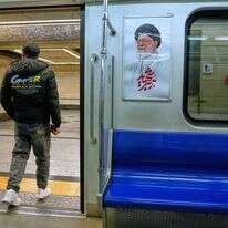 גבר יורד מרכבת תחתית ליד תמונה של המנהיג העליון האיראני המנוח, האייתוללה עלי חמינאי, בטהרן, איראן | AP Photo/Vahid Salemi