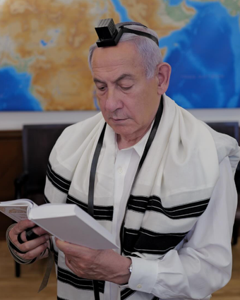 ראש הממשלה, בנימין נתניהו, מניח ביום הזיכרון ה'תשפ"ה את תפיליו של רס"ם במיל' יוסי הרשקוביץ הי"ד, שנפל ברצועת עזה במהלך המלחמה | עמוד הפייסבוק של בנימין נתניהו