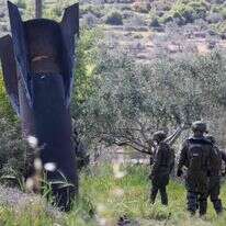 חיילים צה"ל בודקים את שרידי הטיל האיראני שנחת בכפר חארס | ASHTIYEH / AFP