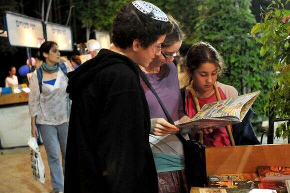 שלושה בני נוער קוראים ספר ביריד ספרים לילי בגן הפעמון, כחלק משבוע הספר העברי | סופי גורדון / פלאש 90 שלושה בני נוער קוראים ספר ביריד ספרים לילי בגן הפעמון, כחלק משבוע הספר העברי | סופי גורדון / פלאש 90