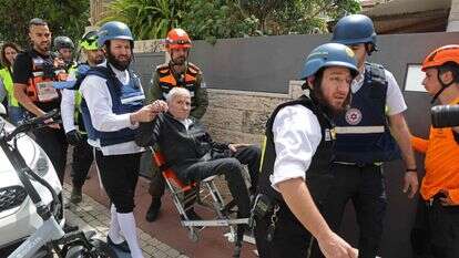 כוחות ההצלה של ישראל מפנים פצוע מזירת תקיפה איראנית שפגעה בשכונת מגורים ברמת גן | AFP כוחות ההצלה של ישראל מפנים פצוע מזירת תקיפה איראנית שפגעה בשכונת מגורים ברמת גן | AFP