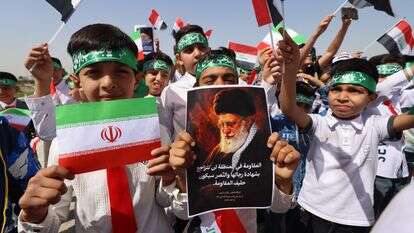 ילדים עיראקים תומכי המשטר האיראני מניפים תמונות של המנהיג העליון שחוסל עלי חמינאי ודגלי הרפובליקה האסלאמית | AFP