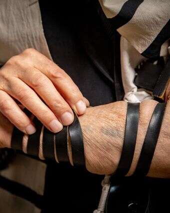 שורד השואה, משה דוד מאיר, עם תפילין ומספר מקועקע על זרועו, בביתו בירושלים | חיים גולדברג, פלאש 90