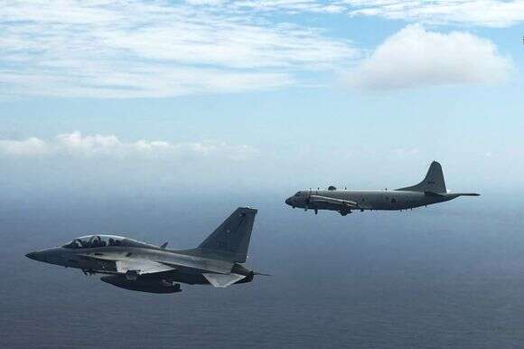 מטוס קרב FA-50 (משמאל) של חיל האוויר הפיליפיני טס לצד מטוס סיור ימי P-3 אוריון של כוח ההגנה העצמית היפני במהלך תרגיל צבאי משותף בים סין הדרומי | This handout photo taken on February 26, 2026 and released on February 27 by the Armed Forces of the Philippines-Public Affairs Office (AFP-PAO) shows a Philippine air force 
Armed Forces of the Philippines-Public Affairs Office (AFP-PAO) / AFP