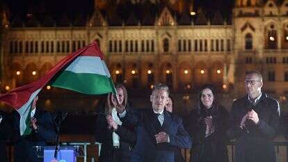 פטר מגיאר, מנהיג מפלגת TISZA השמרנית הפרו-אירופית, מנופף בדגל הלאומי במהלך חגיגות במסיבת ליל הבחירות על גדות נהר הדנובה כשברקע בניין הפרלמנט, בבודפשט לאחר הבחירות הכלליות בהונגריה | AFP