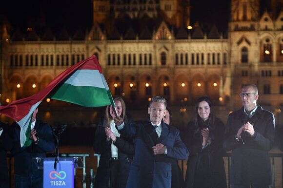 פטר מגיאר, מנהיג מפלגת TISZA השמרנית הפרו-אירופית, מנופף בדגל הלאומי במהלך חגיגות במסיבת ליל הבחירות על גדות נהר הדנובה כשברקע בניין הפרלמנט, בבודפשט לאחר הבחירות הכלליות בהונגריה | AFP פטר מגיאר, מנהיג מפלגת TISZA השמרנית הפרו-אירופית, מנופף בדגל הלאומי במהלך חגיגות במסיבת ליל הבחירות על גדות נהר הדנובה כשברקע בניין הפרלמנט, בבודפשט לאחר הבחירות הכלליות בהונגריה | AFP