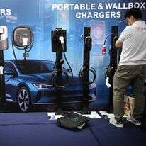 עובד מסדר סוגים שונים של מטענים לרכב חשמלי תוצרת סין, המוצגים ביום הפתיחה של תערוכת הרכב הבינלאומית במנילה | AFP