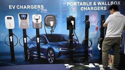 עובד מסדר סוגים שונים של מטענים לרכב חשמלי תוצרת סין, המוצגים ביום הפתיחה של תערוכת הרכב הבינלאומית במנילה | AFP